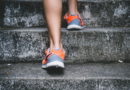 Person wearing orange and gray shoes walking up concrete stairs.