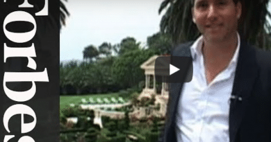 Man in business attire poses near a luxury real estate property.