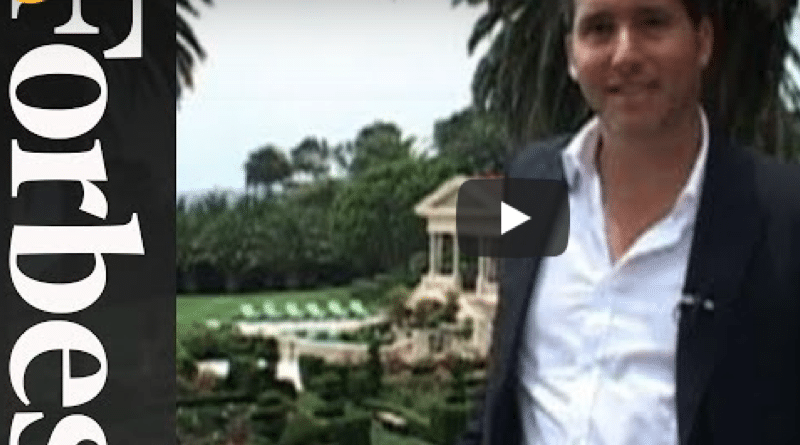 Man in business attire poses near a luxury real estate property.