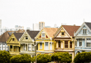 Colorful Victorian houses lined up in a row on a sunny day.