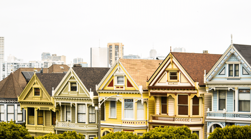 Colorful Victorian houses lined up in a row on a sunny day.