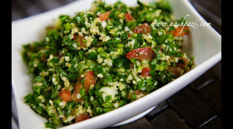 Fresh tabbouleh salad with parsley, tomatoes, and bulgur in a white bowl.