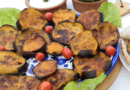 A plate of grilled eggplant slices garnished with lettuce and cherry tomatoes.