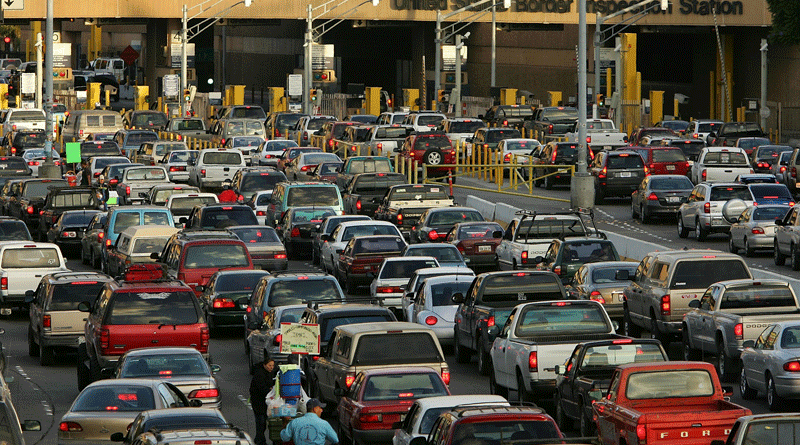 Heavy traffic at a toll plaza with multiple lanes and many cars.