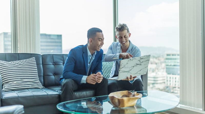 Two businessmen reviewing documents in a modern office.