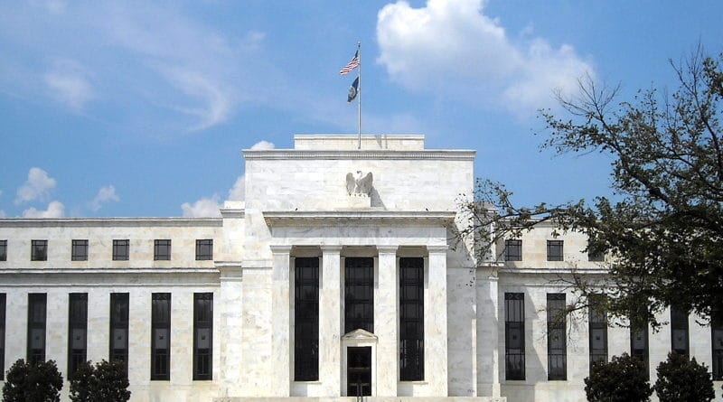The Federal Reserve building under a blue sky with some clouds.