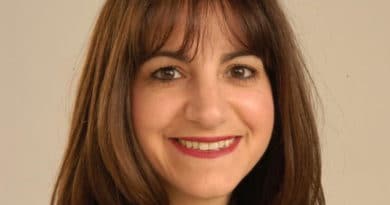 Portrait of a smiling woman with brown hair and bangs.