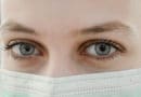 Close-up of blue eyes above a surgical mask.