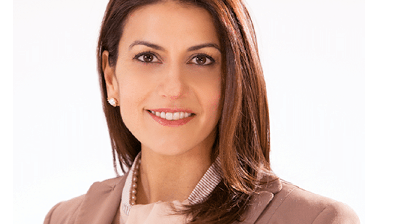 Professional woman smiling in business attire.