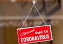 Red sign reading 'Closed due to CORONAVIRUS' hanging on a glass door.