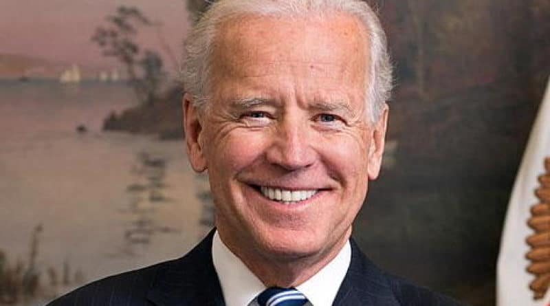 Smiling elderly man in suit and striped tie.