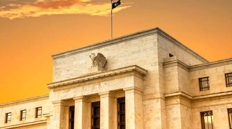 Historic building with flags at sunset under a dramatic sky.