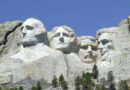 Mount Rushmore with carved faces of four US presidents against a clear blue sky.