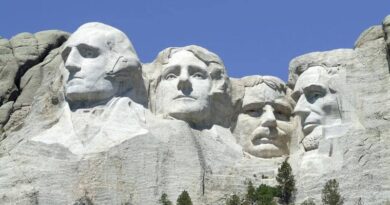 Mount Rushmore with carved faces of four US presidents against a clear blue sky.