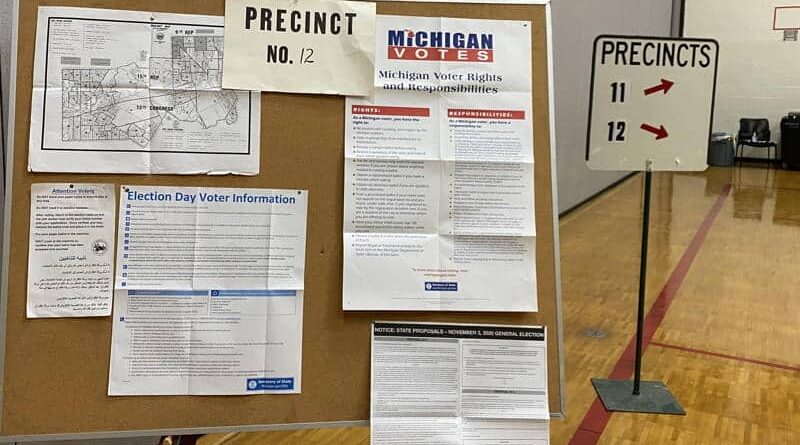 A precinct board displays voter information and instructions inside a polling station.