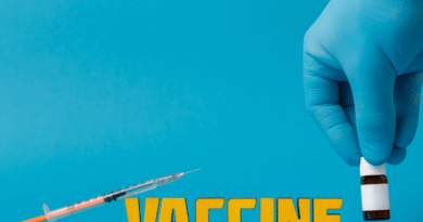 Syringe poised to inject vaccine text against blue background.