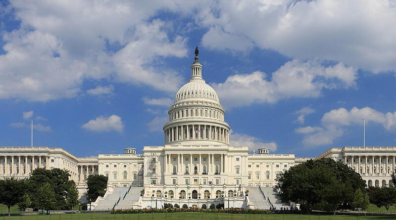 The United States Capitol building under a partly cloudy sky.