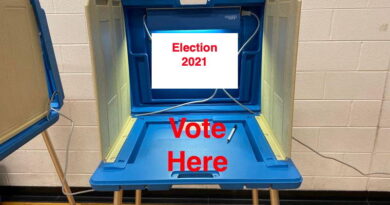 A voting booth with a sign saying 'Election 2021' and 'Vote Here'.