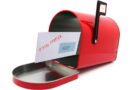 Red mailbox with an open door and a letter inside.