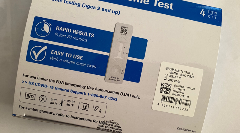 COVID-19 at-home test kit with a test strip showing results.
