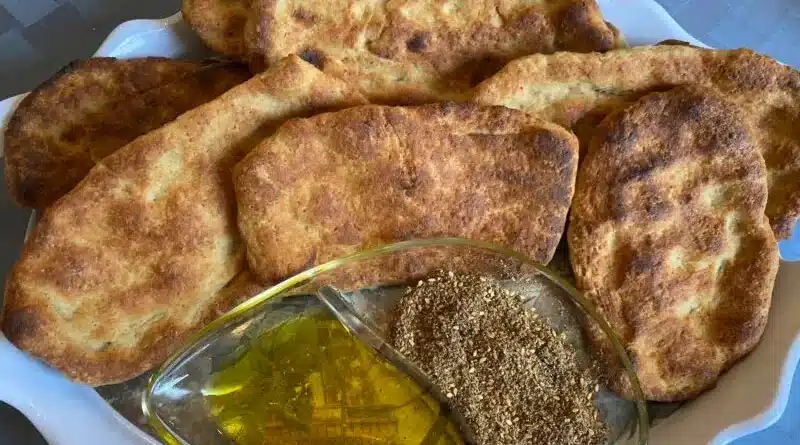 Freshly baked flatbreads served with olive oil and za'atar spice.