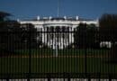 The White House behind a black fence on a clear day.
