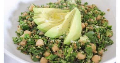 A fresh tabbouleh salad garnished with avocado slices.