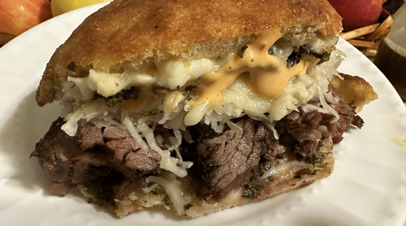 Close-up of a juicy roast beef sandwich with melted cheese.