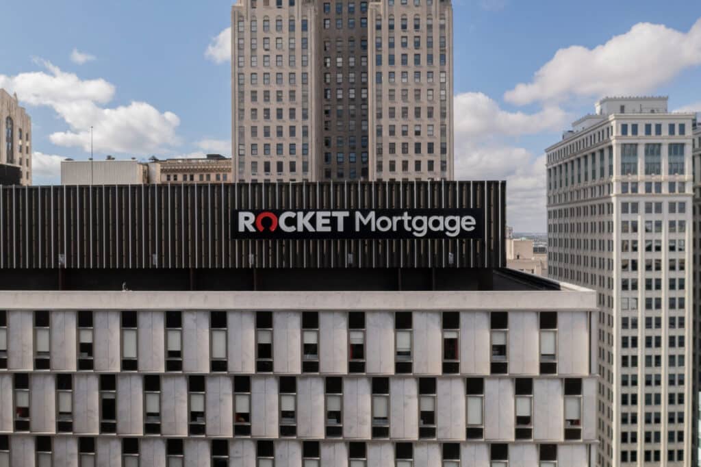 Rocket Mortgage sign on a building under a partly cloudy sky.