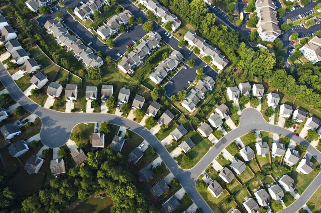 Aerial view of suburban neighborhood with houses and curved roads.