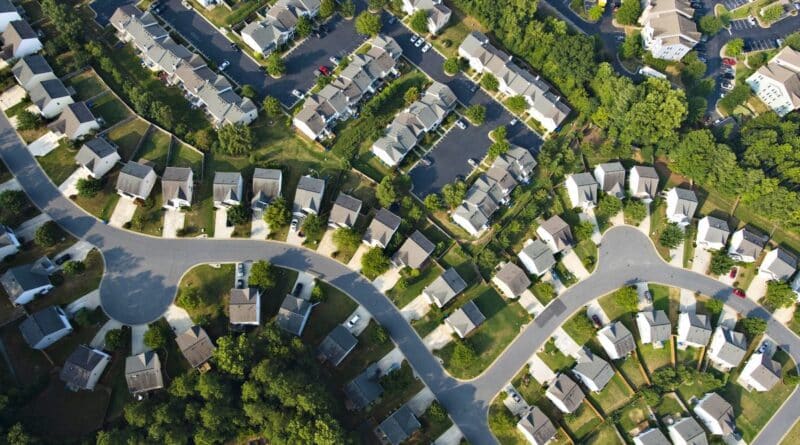 Aerial view of suburban neighborhood with houses and curved roads.